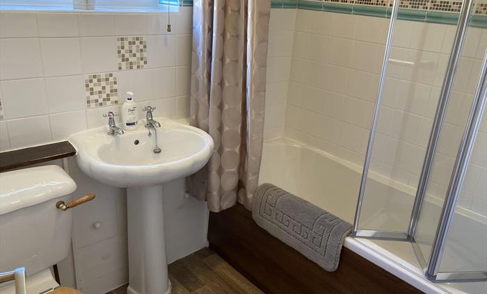 Downstairs bathroom and wc. Modern over-bath shower with shower screen